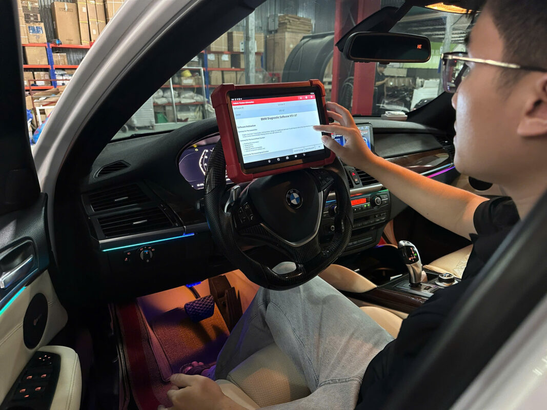Kỹ thuật viên sử dụng máy chẩn đoán Launch trong garage (ASCOM)